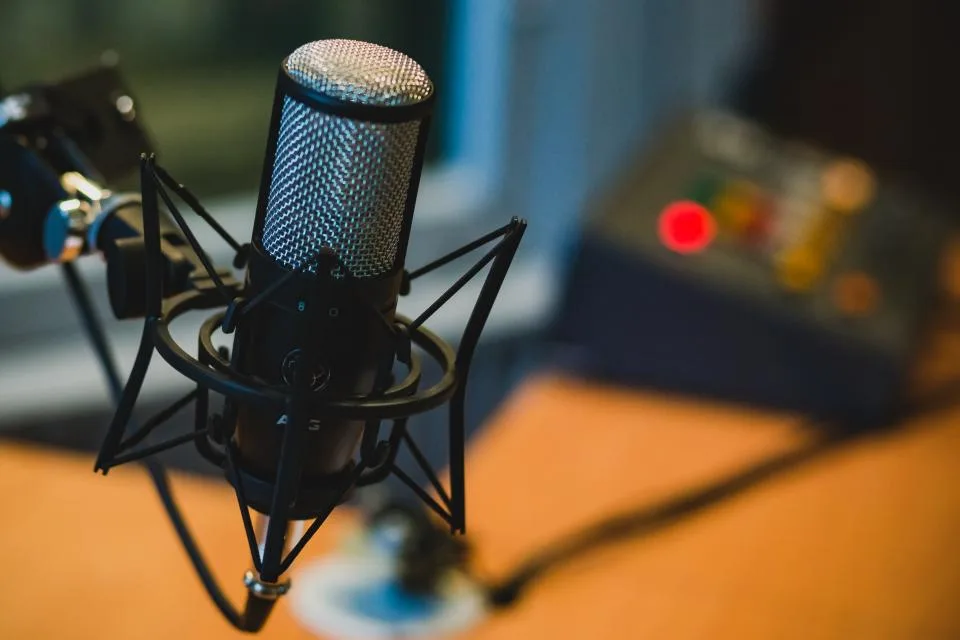 Microfone em primeiro plano, com o fundo desfocado, em situação de entrevista