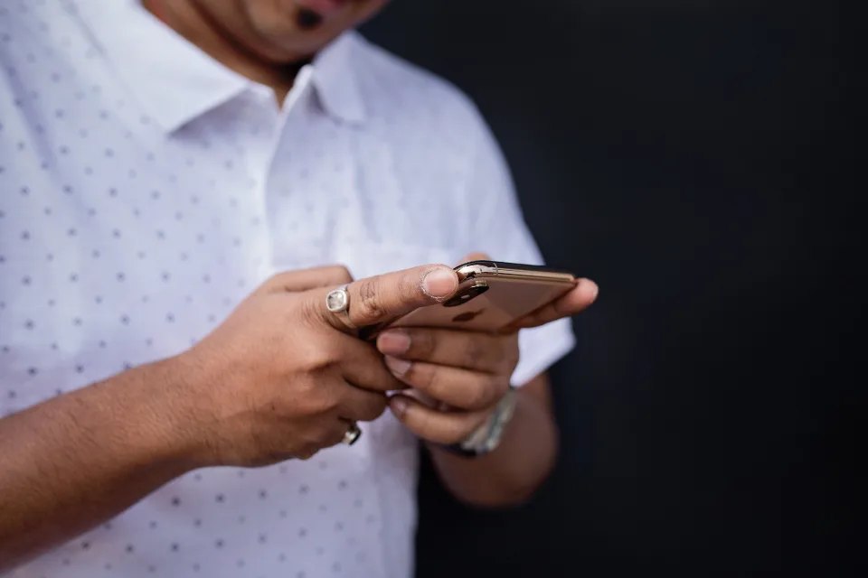 Mãos digitando uma mensagem no celular