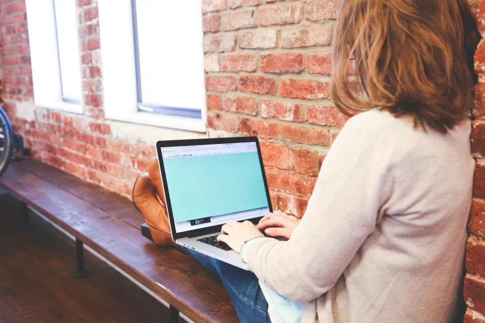 Mulher digitando no notebook em uma mesa de trabalho