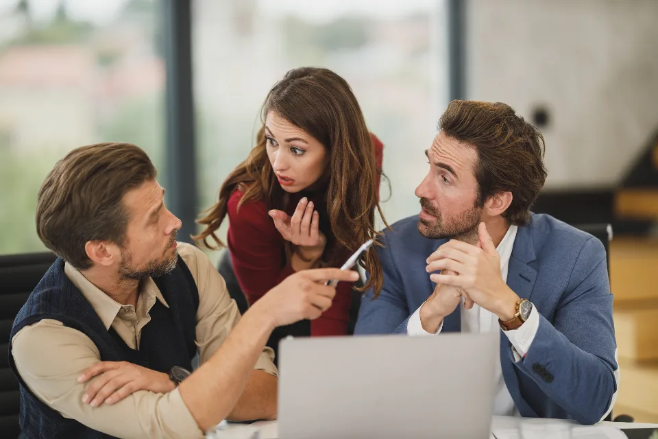 Equipe trabalhando com notebooks numa mesa de reunião