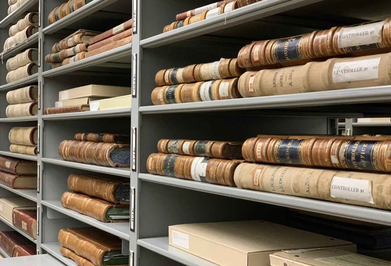 Estantes de arquivo com volumes de registros organizados por lombada