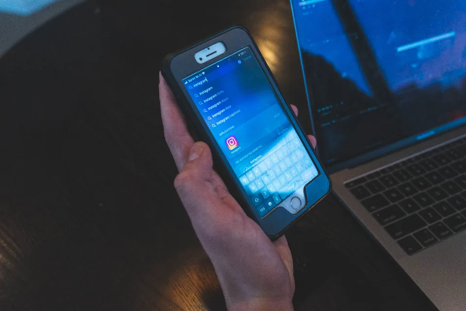 Mão segurando smartphone com uma rede social aberta