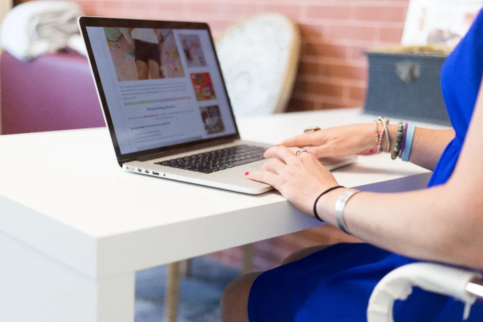 Pessoa trabalhando em um notebook sobre a mesa
