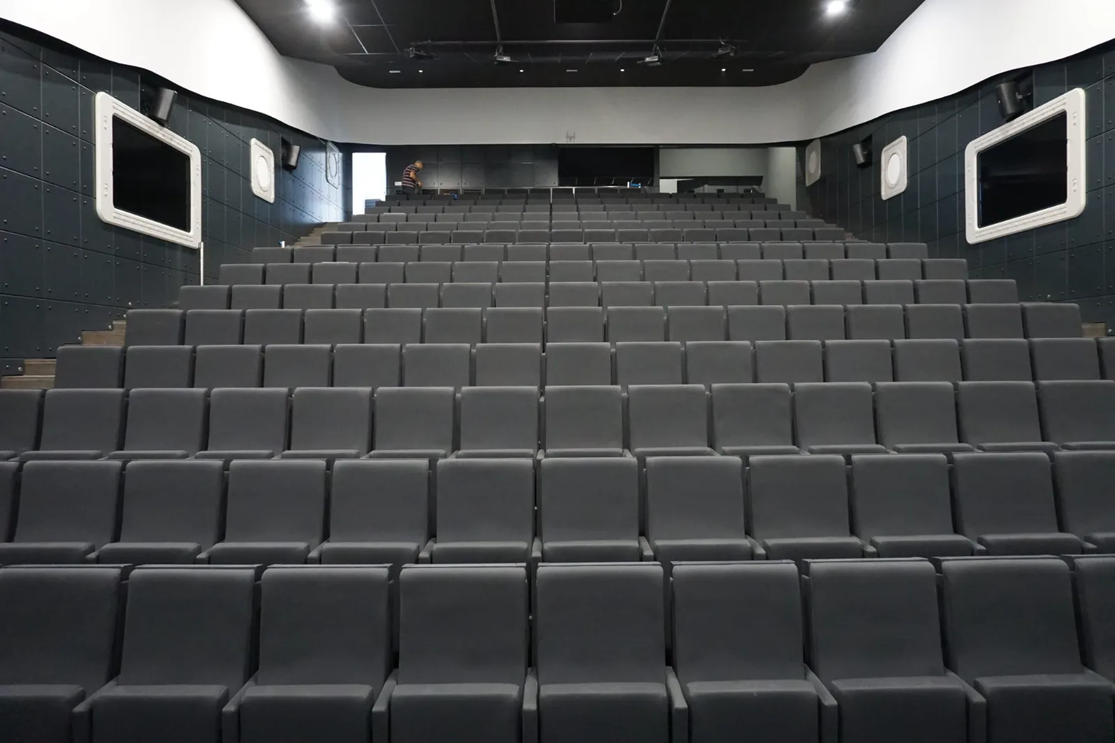 Auditório de conferência com as cadeiras enfileiradas, pronto para receber o público