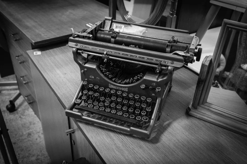 Teclas de uma máquina de escrever antiga em close, com as letras em destaque