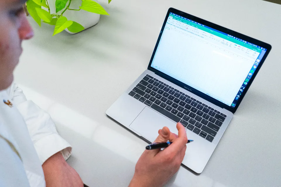 Mão preenchendo um formulário no notebook