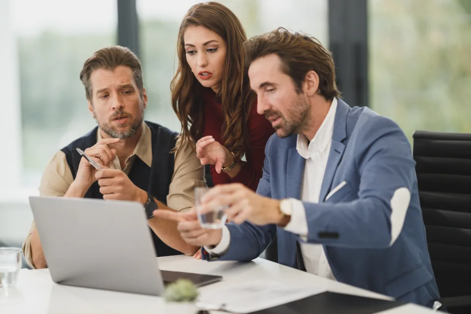 Equipe reunida em torno de um notebook
