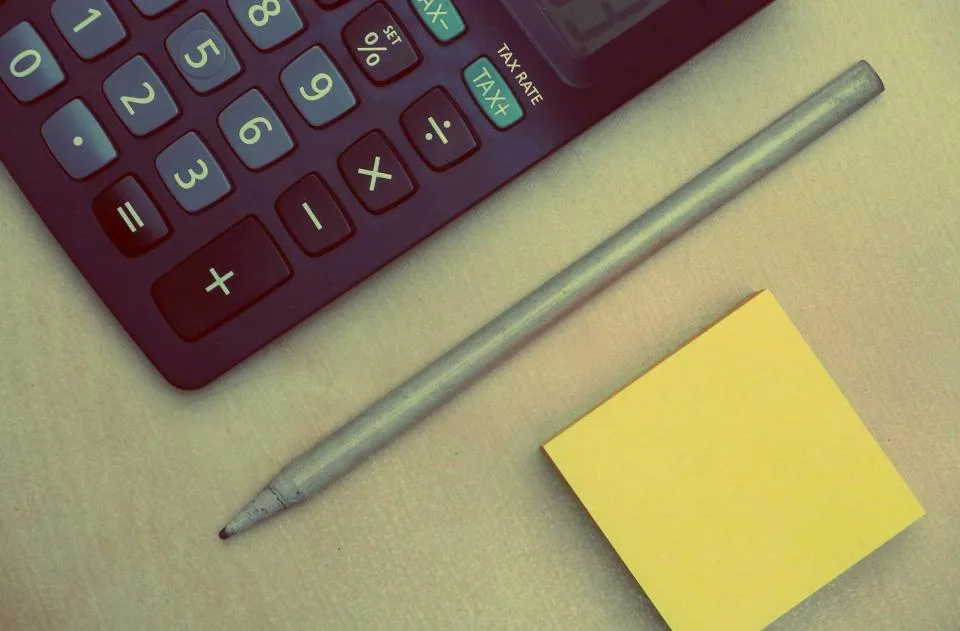 Calculadora, lápis e bloco de notas sobre a mesa