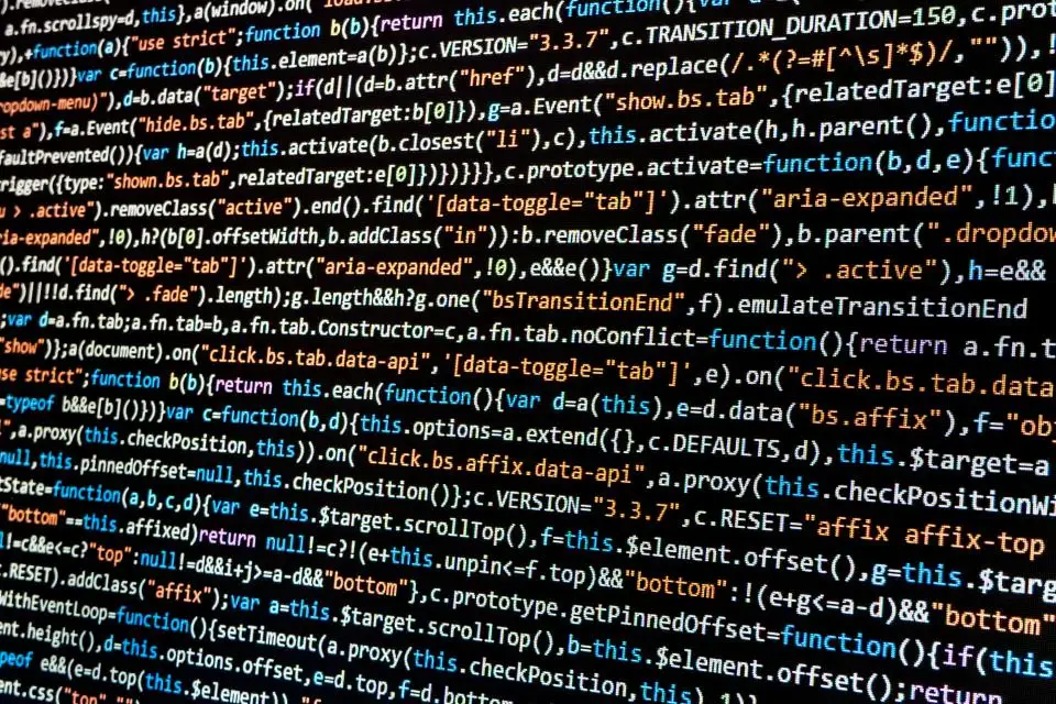 Tela de computador com linhas de código-fonte coloridas sobre fundo escuro