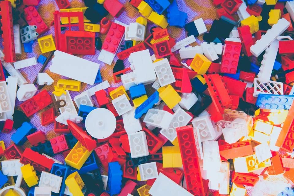 Peças de montar coloridas espalhadas, como blocos prontos que se encaixam para construir algo