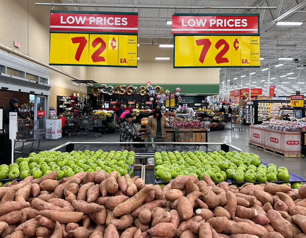 Gôndola de hortifrúti com cartazes de preço no supermercado