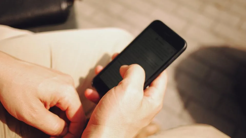 Mãos segurando um celular para responder mensagens
