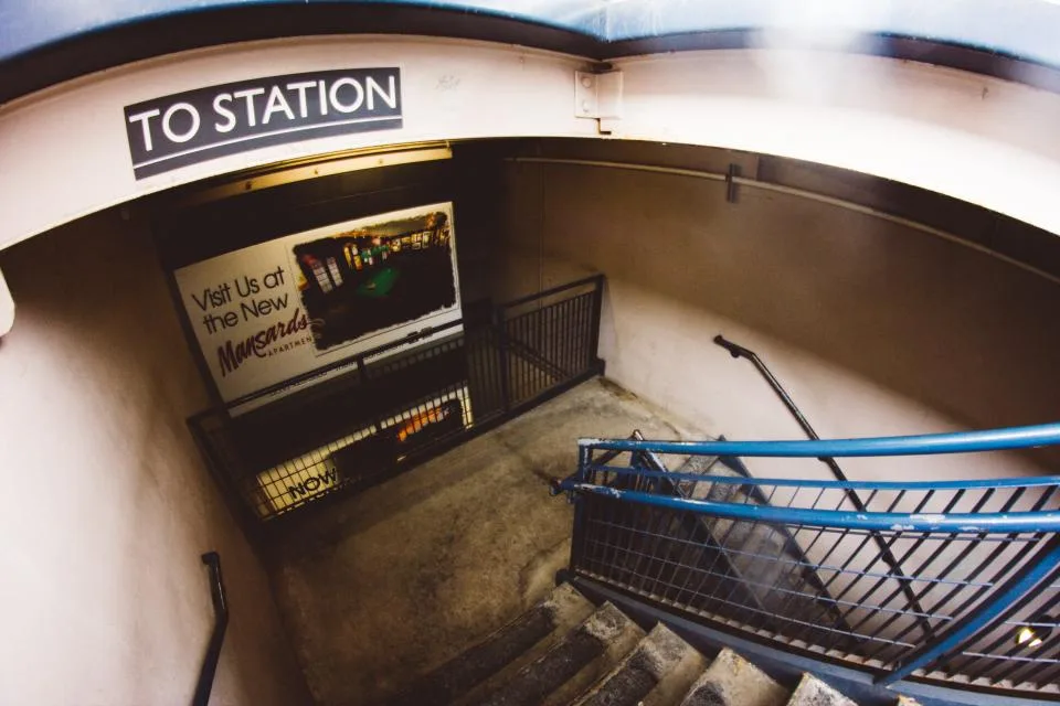 Entrada de estação com cartaz publicitário na parede da escada