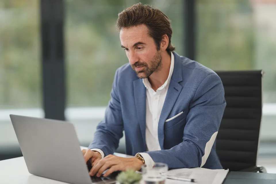 Executivo escrevendo no notebook no escritório