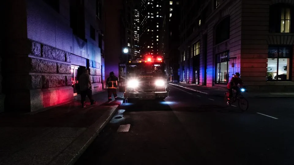 Veículo de emergência com luzes acesas numa rua escura à noite