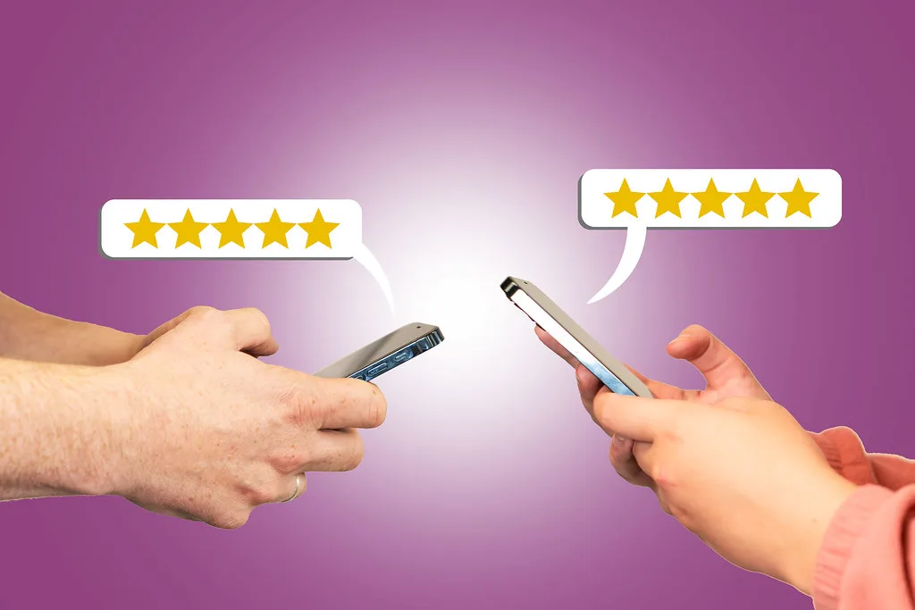 Mãos com celulares exibindo avaliações de cinco estrelas