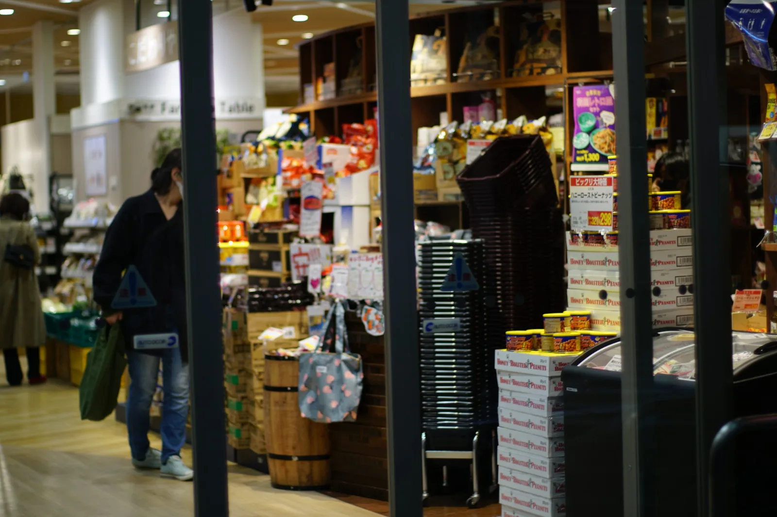 Entrada de um supermercado com prateleiras de produtos e clientes