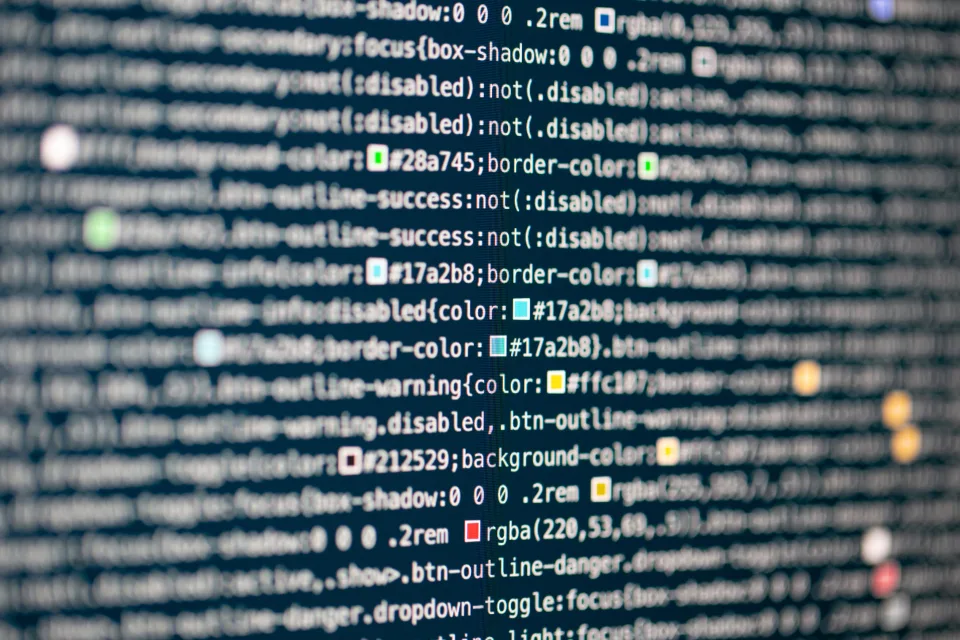 Linhas de código numa tela escura, em close