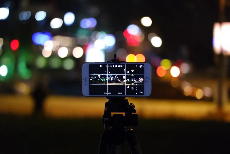 Celular num tripé gravando vídeo na vertical à noite